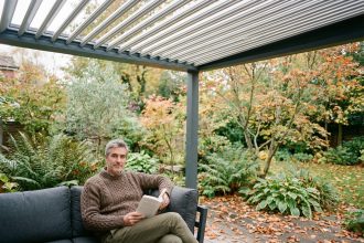 Homme d'âge moyen lisant dans un salon extérieur cosy