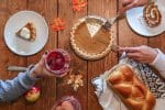 person slicing pie beside bread